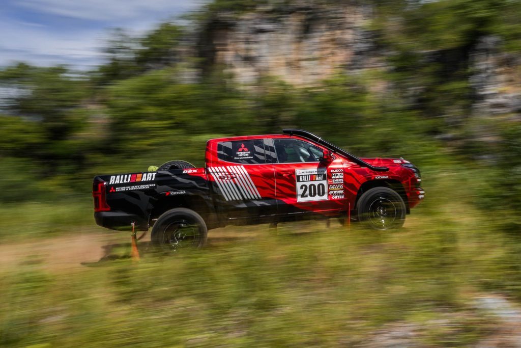 Mitsubishi Triton rally car driving on dirt road at speed