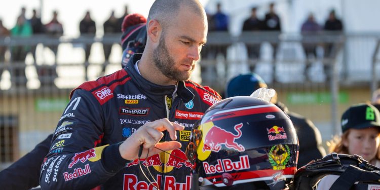 Shane van Gisbergen standing with race helmet