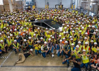 First production Tesla Cybertruck surrounded by employees