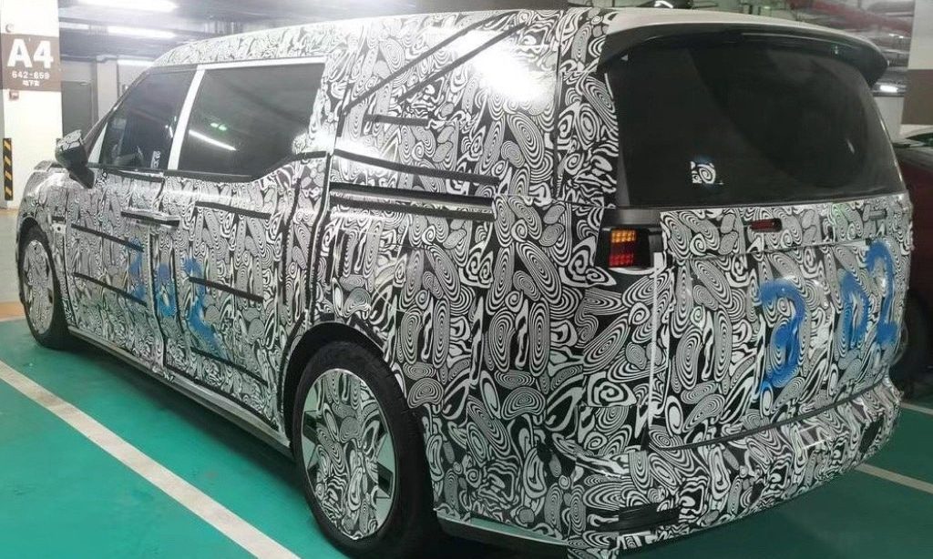 Camouflaged Volvo electric people mover parked in car park