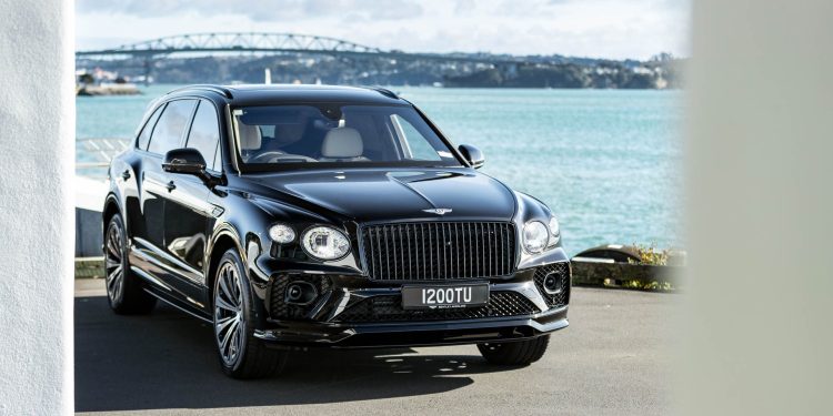 Front quarter of Bentley Bentayga EWB, with Auckland harbour bridge behind