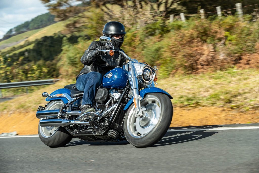 Harley-Davidson Fat Boy 114 takes a corner, close up, in blue and chrome