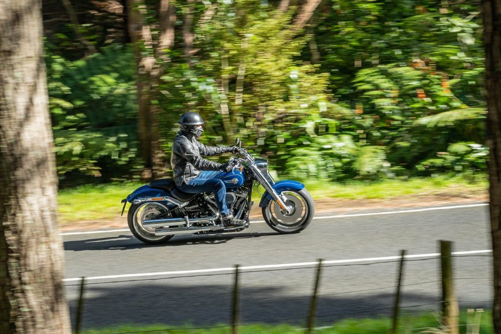 Harley-Davidson Fat Boy 114 driving in the forest, the other way