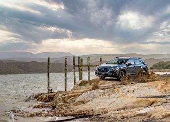 Subaru Crosstrek parked on rocks next to the sea