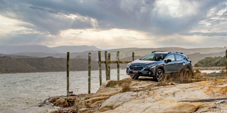 Subaru Crosstrek parked on rocks next to the sea