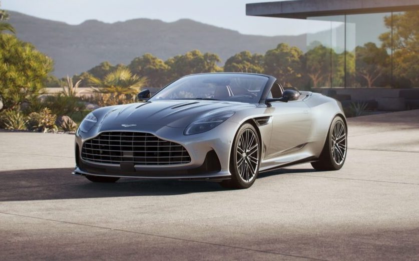 Aston Martin DB12 Volante with roof down parked by house