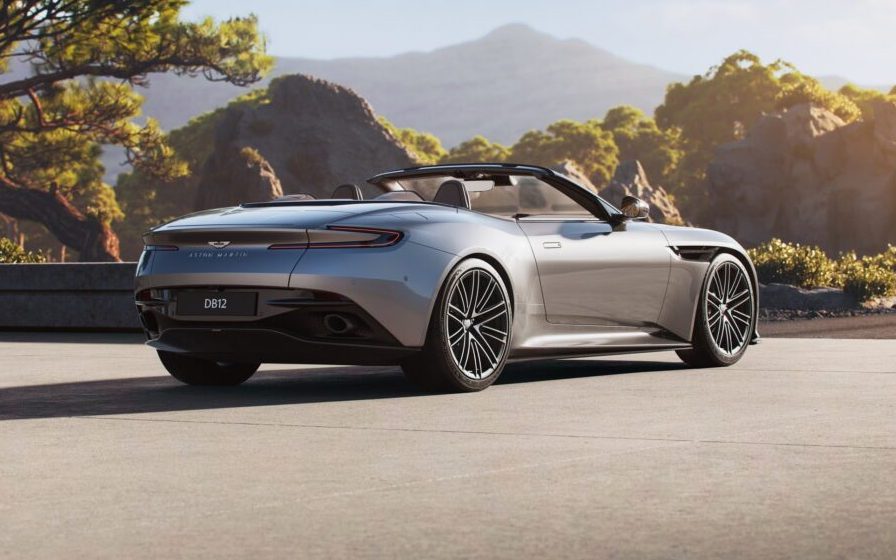Aston Martin DB12 Volante with roof down parked by trees