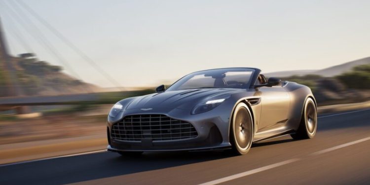 Aston Martin DB12 Volante with roof down driving on road