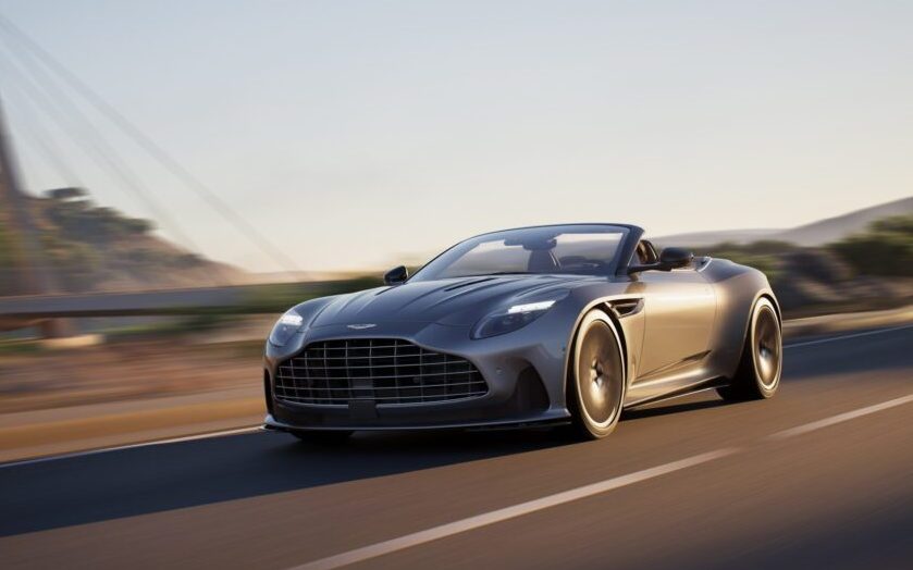 Aston Martin DB12 Volante with roof down driving on road