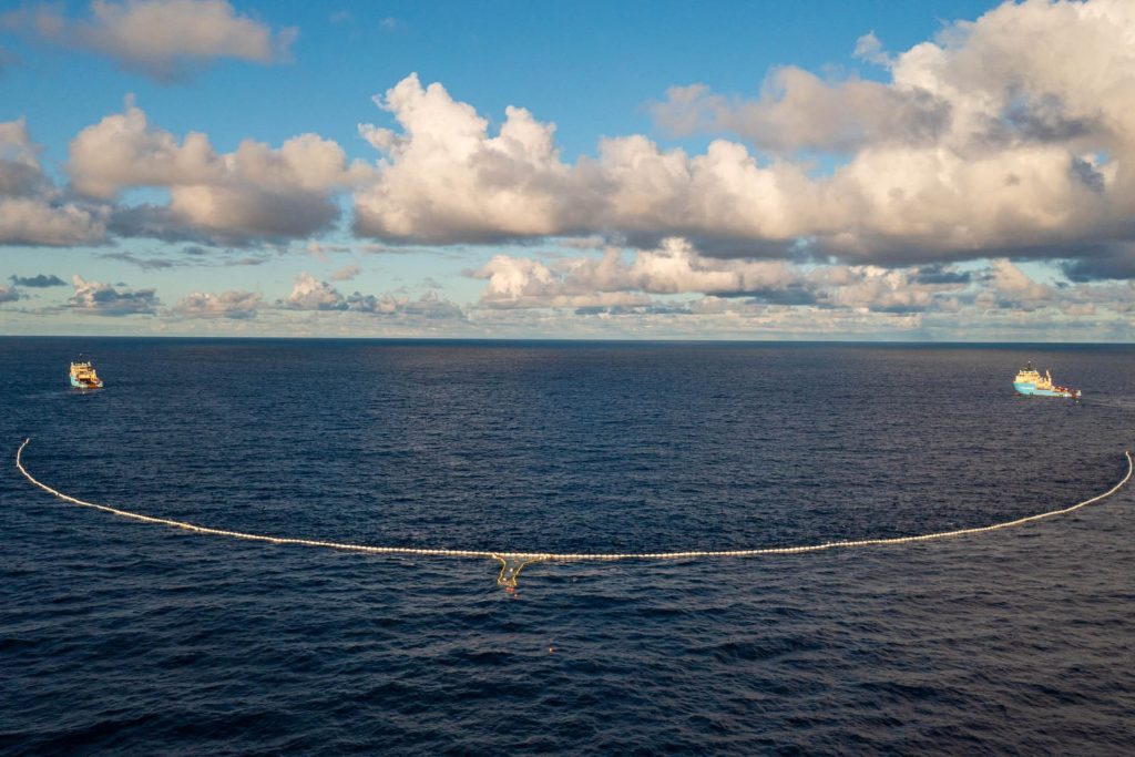 Two ships towing rubbish collecting net in ocean