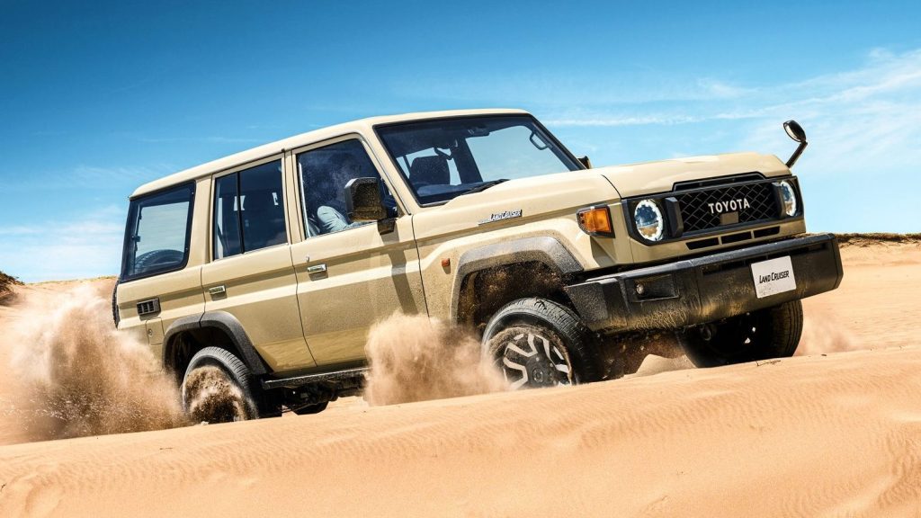 Facelift Toyota Land Cruiser 70 Series driving through sand