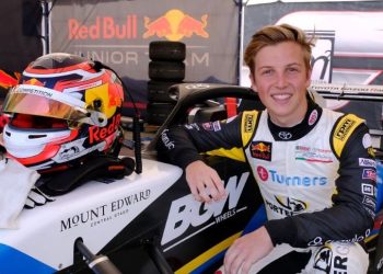 Liam Lawson standing next to open wheel race car