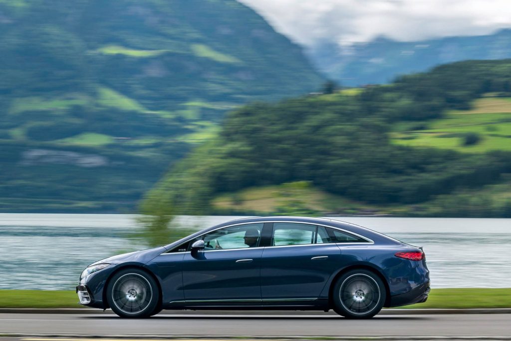 Mercedes-Benz EQS 450 4Matic driving past lake