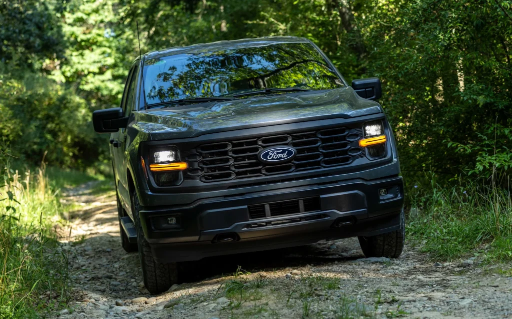 2024 Ford F-150 STX driving through trees