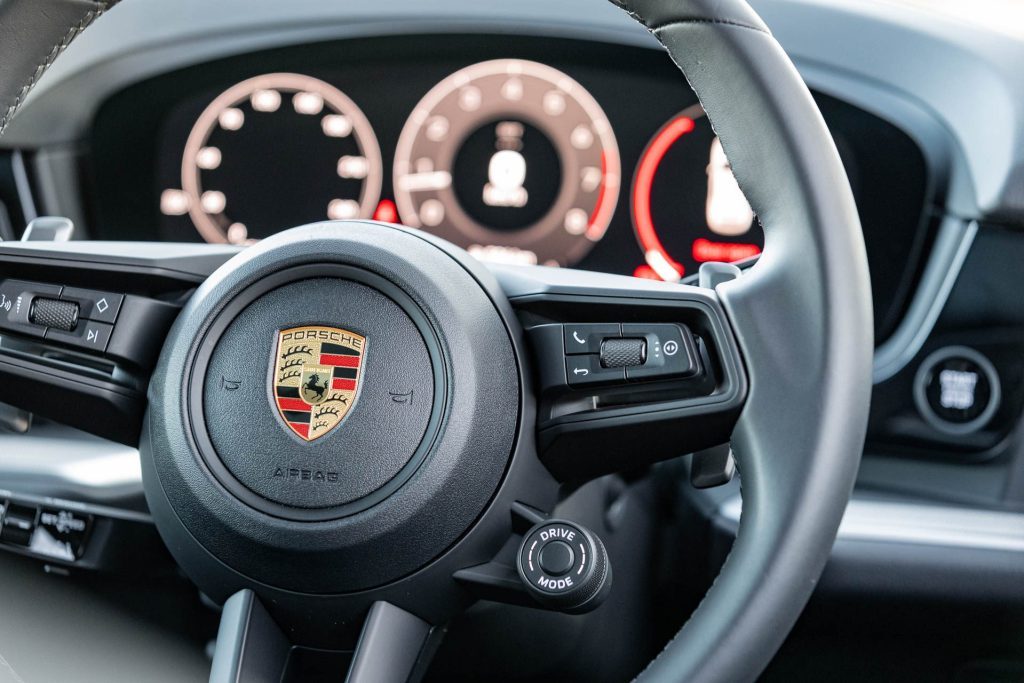 Porsche steering wheel detail shot, showing Drive Mode button