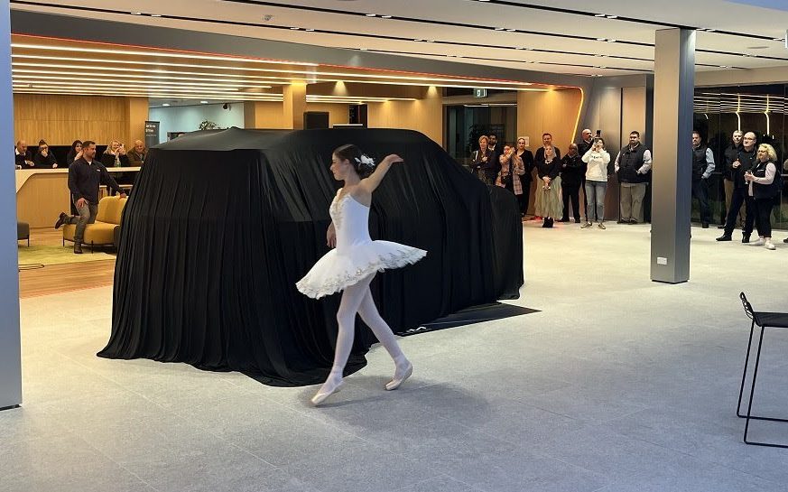 Ballerina dancing around Kia EV9 under cover