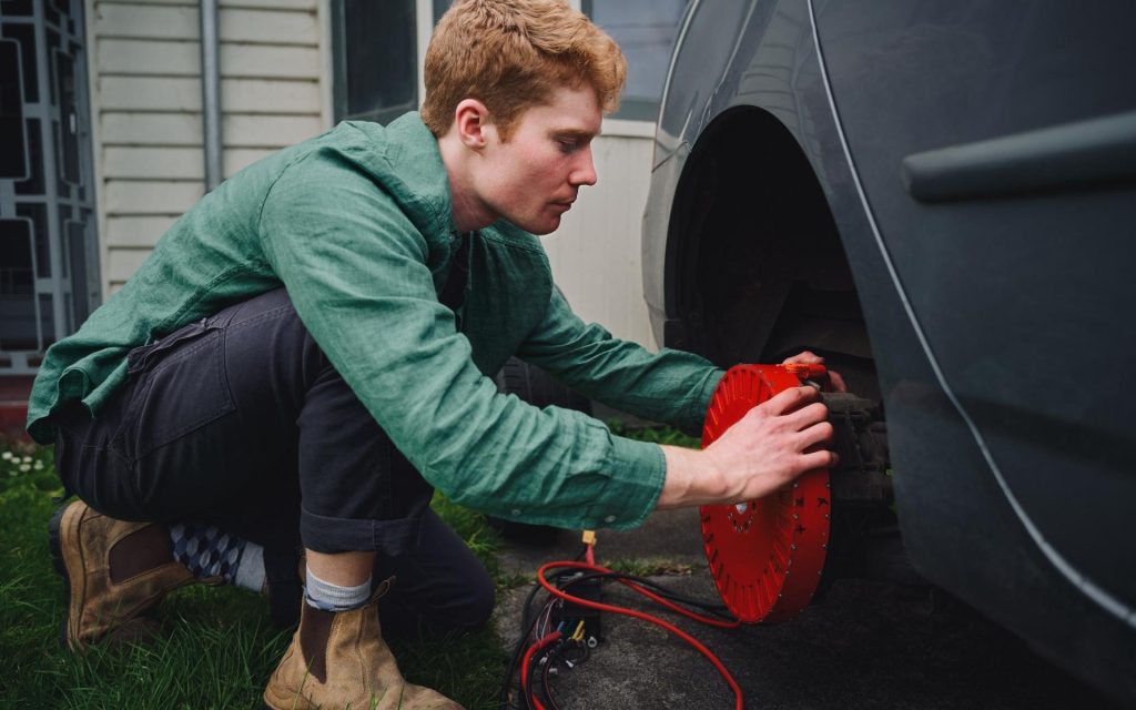 Alexander Burton placing REVR electric motor onto his car