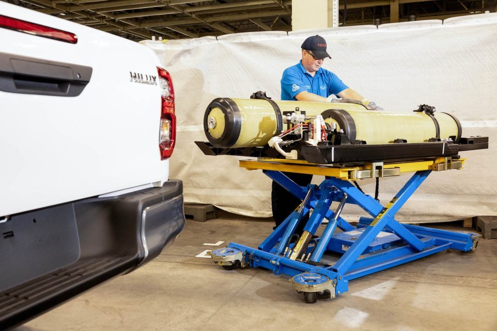 Man working on high-pressure fuel tanks for hydrogen-powered Toyota Hilux