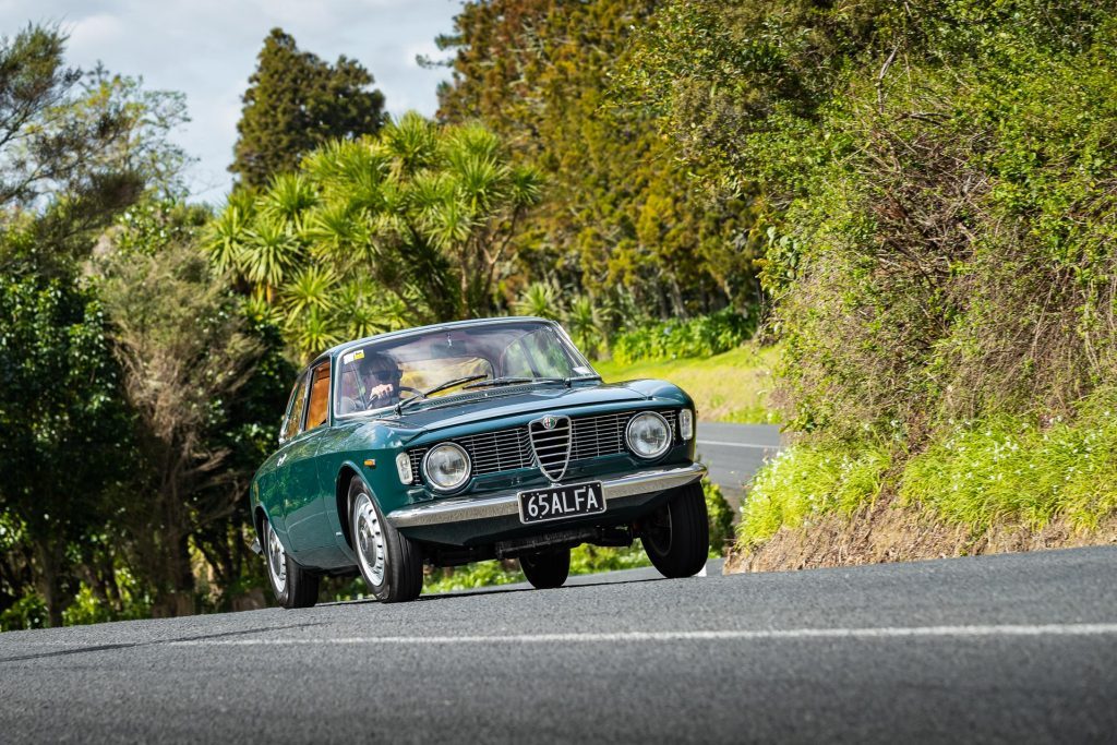 Alfa Romeo Giulia Sprint GT taking a corner at pace, front quarter angle