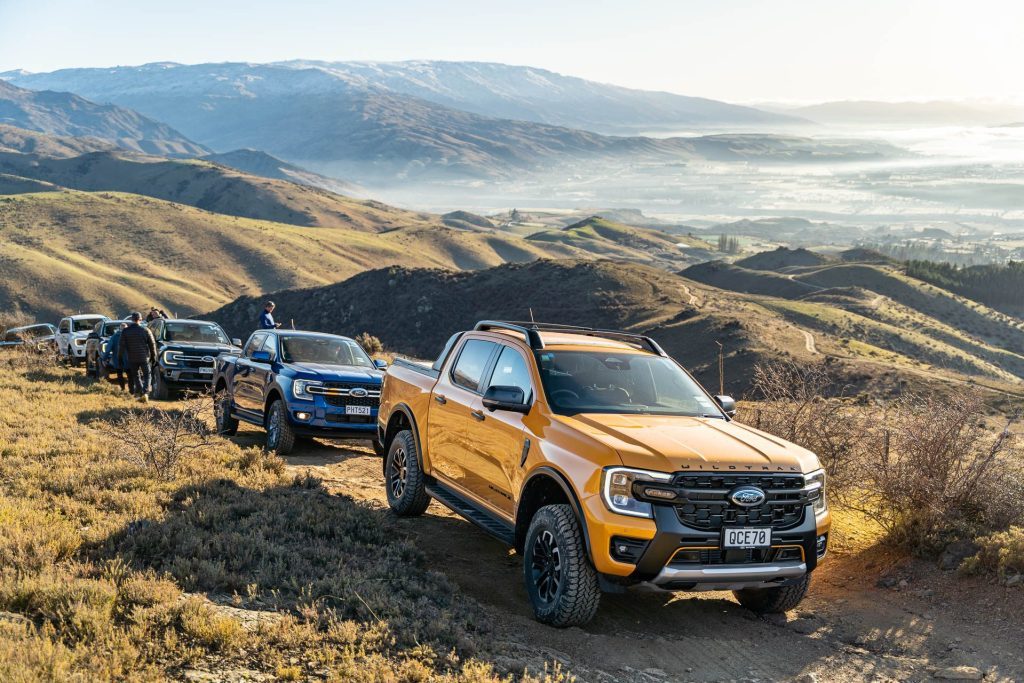 Ford Ranger Wildtrak X, with lineup of Fords behind it. On a mountain range