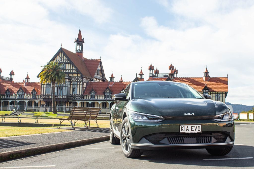 Kia EV6 Air Long Range front quarter, parked in front of massive mansion