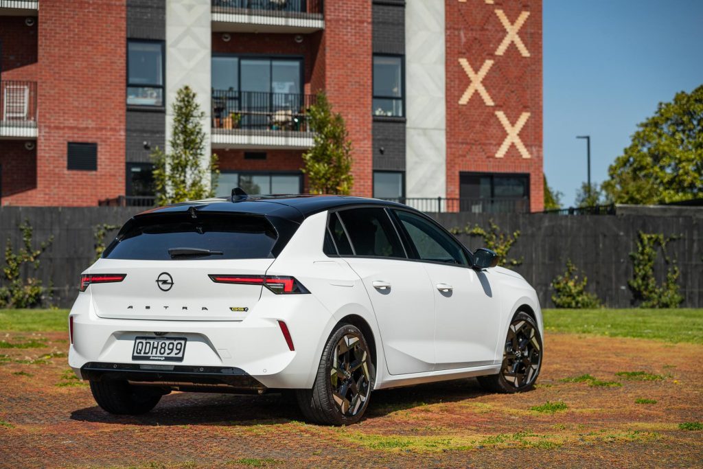 Opel Astra GSe rear quarter full view, parked on red grass