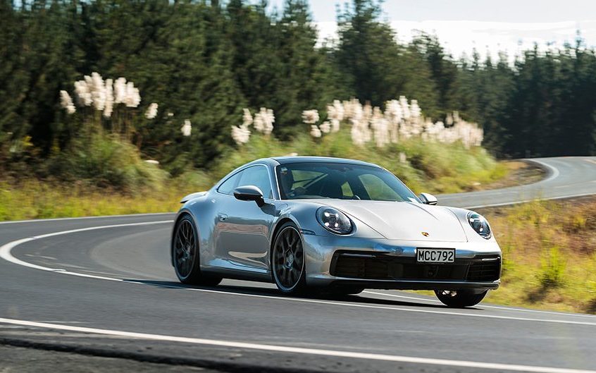 Porsche 911 driving around corner at speed