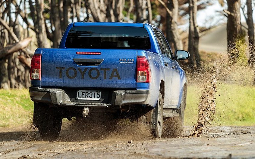 Toyota Hilux driving through muddy puddle
