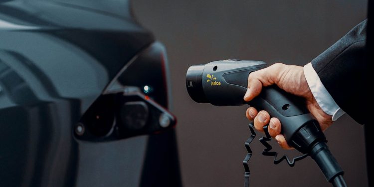 Man holding electric car charging plug