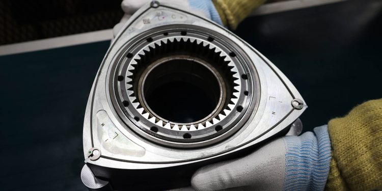 Person holding Mazda rotary engine rotor