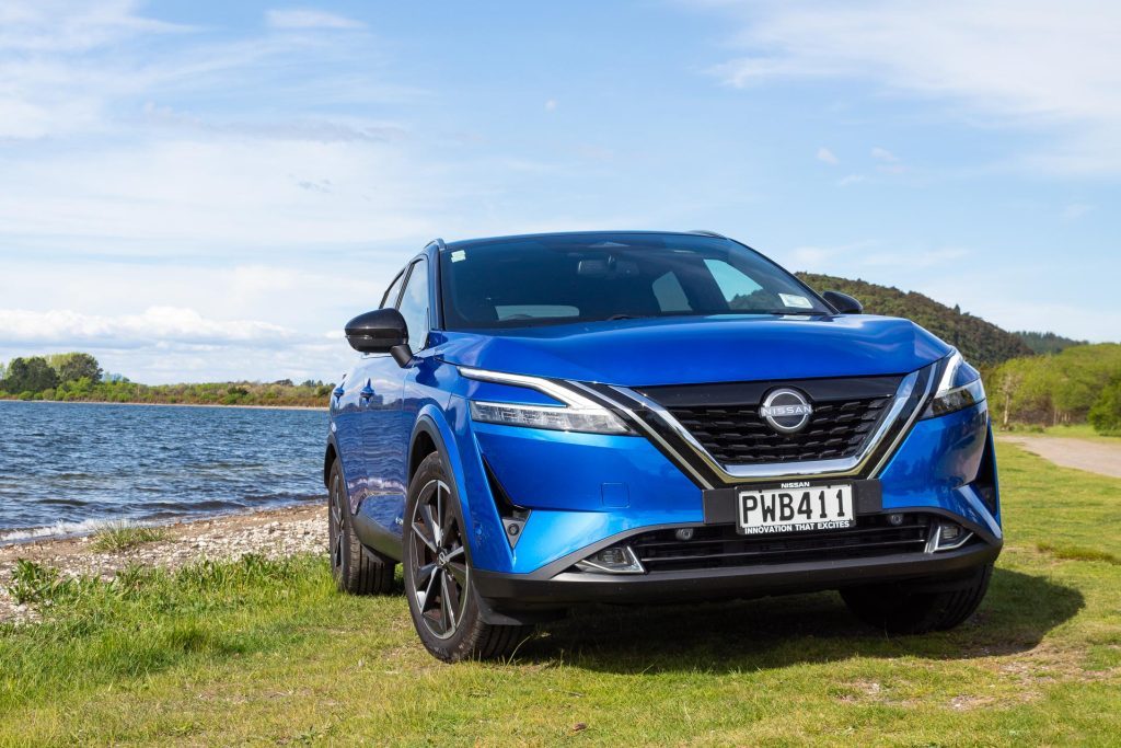 Nissan Qashqai e-Power parked on grass next to a beach