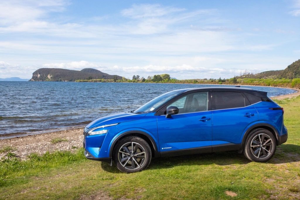 Nissan Qashqai Ti-L e-Power parked alongside a beach, pictured in blue