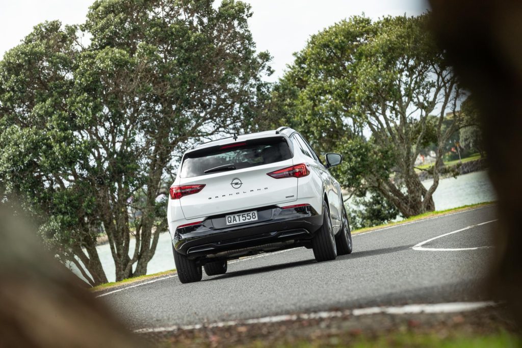 Opel Grandland Hybrid SRi in white cornering, shown from the rear