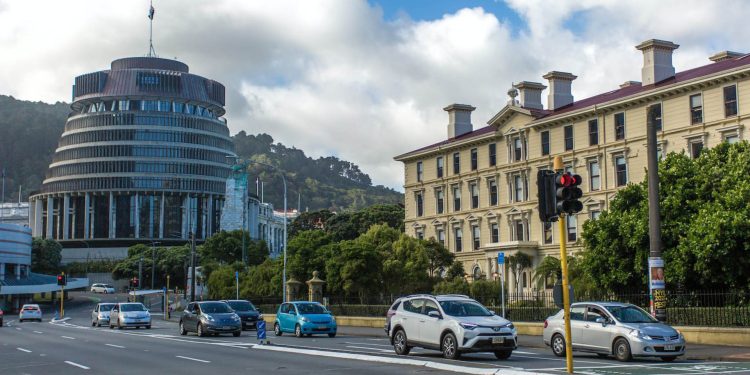 Cars driving on road past beehive in Wellington
