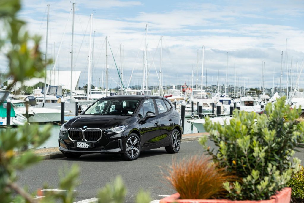 BMW 225e Active Tourer, in black, parked at a marina