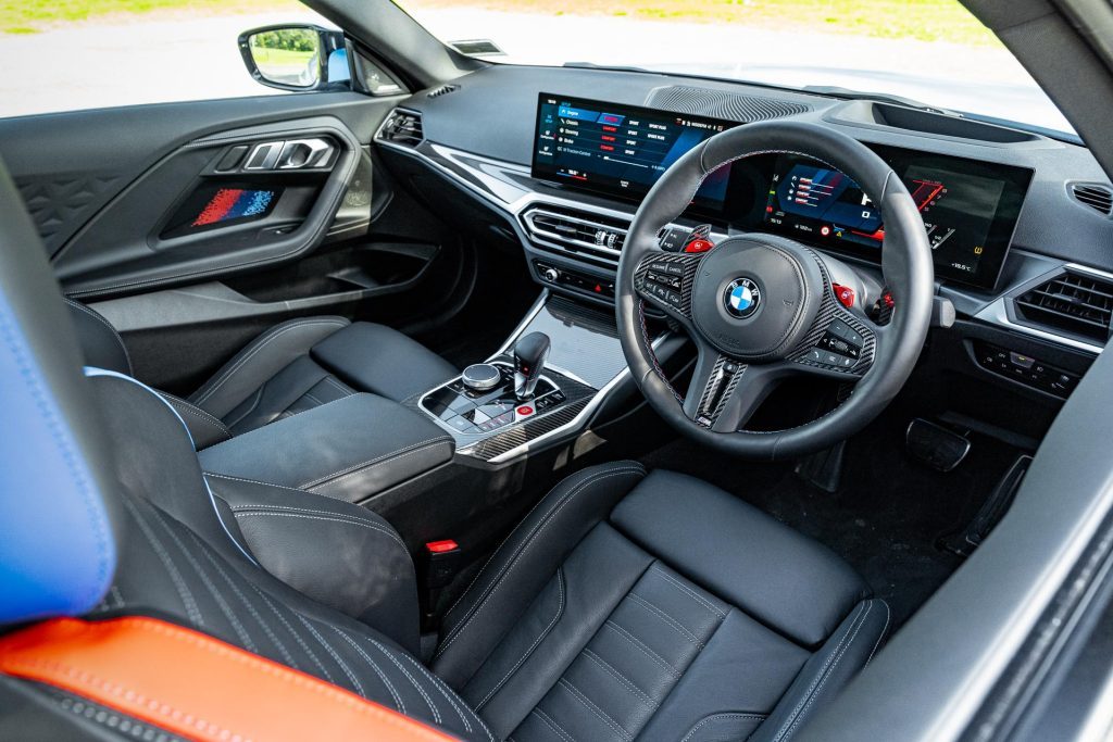 BMW M2 Competition front interior view, with red and blue accents