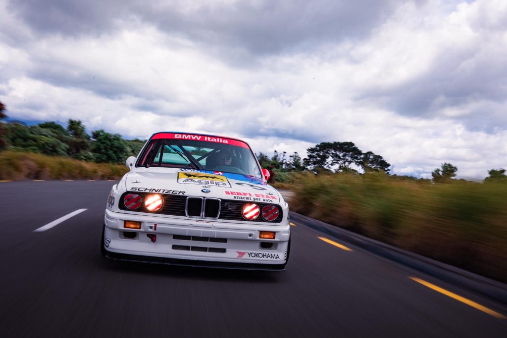 Chase shot of the BMW M3 Group A, in white, with taped headlights