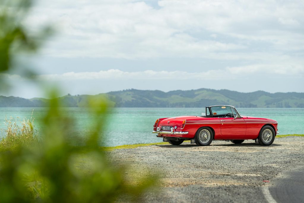 1965 MGB parked on a New Zealand shorefront, showing rear