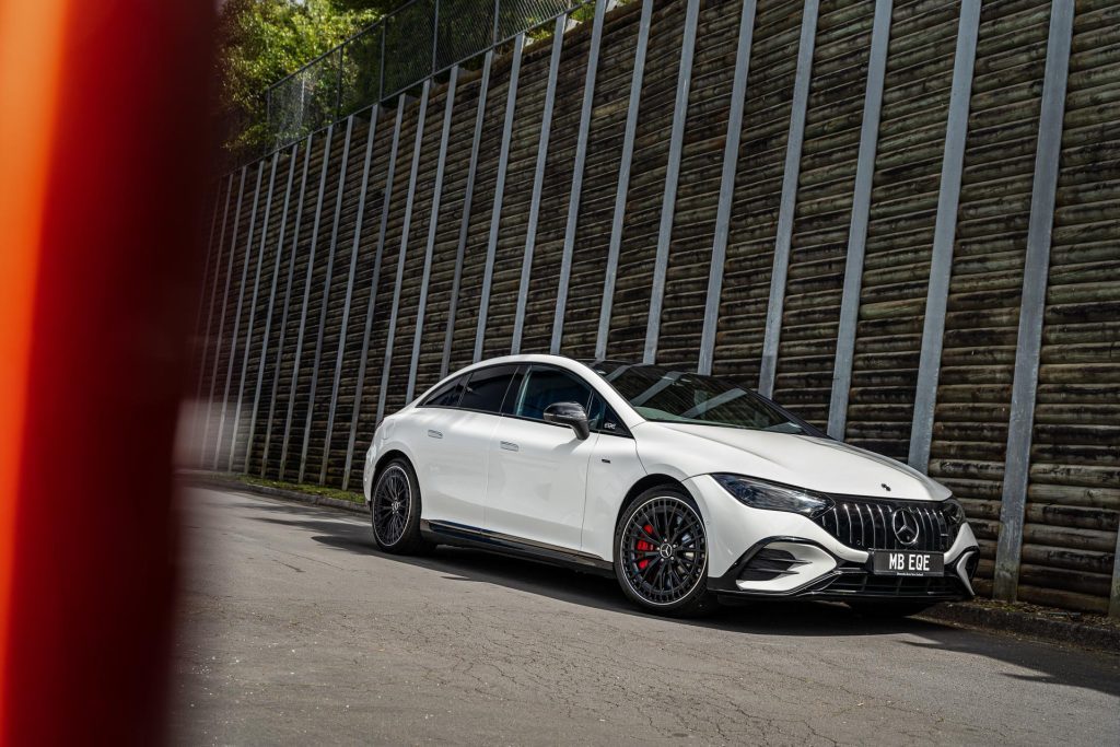 Mercedes-AMG EQE53 4Matic front quarter shown in white, next to large wall