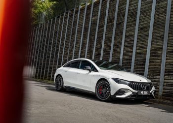 Mercedes-AMG EQE53 4Matic front quarter shown in white, next to large wall