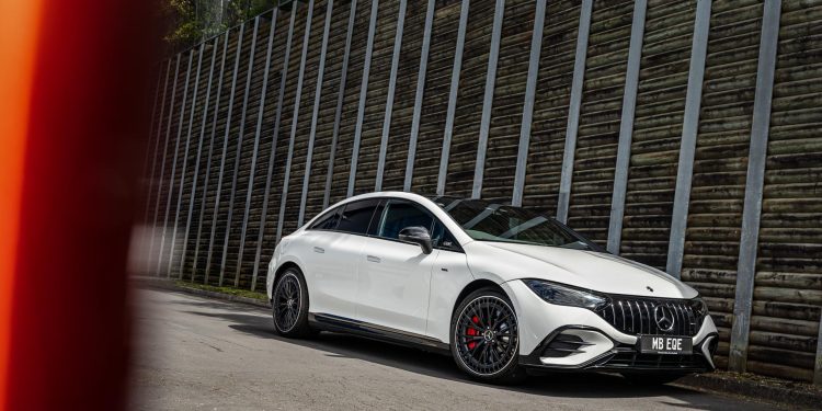Mercedes-AMG EQE53 4Matic front quarter shown in white, next to large wall