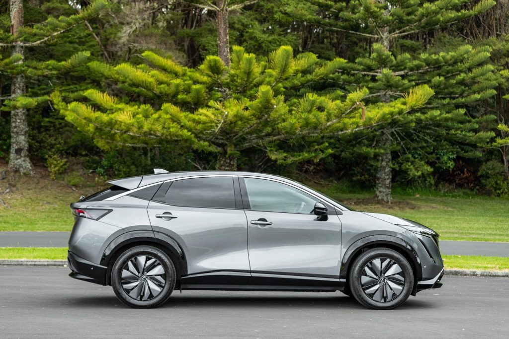 Nissan Ariya side profile shot with trees behind