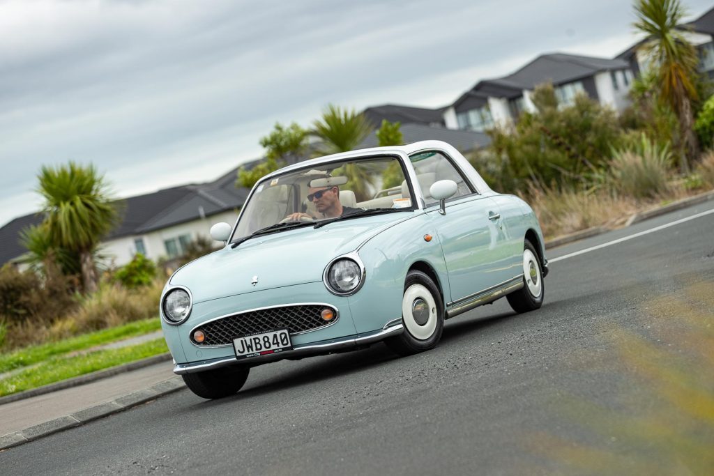 Nissan Figaro classic, taking a corner at a roundabout