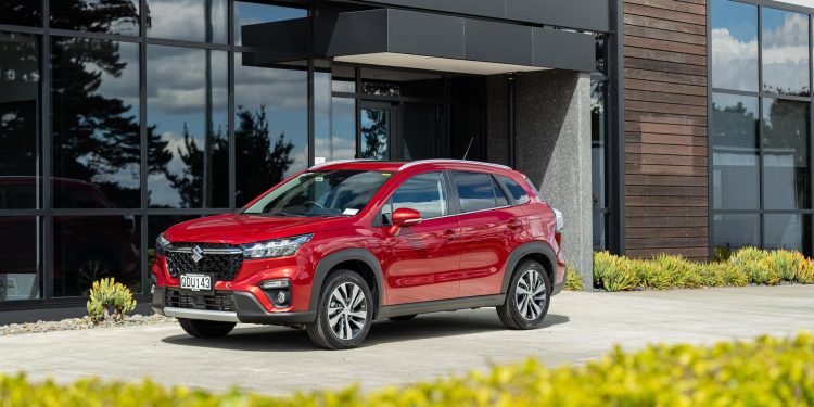 Suzuki S-Cross Hybrid in red, parked outside an office building