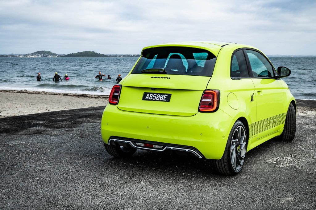 Abarth 500e parked on boat ramp by swimmers at St Heliers in Auckland, New Zealand