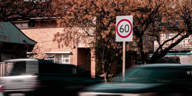 Car driving past speed limit sign