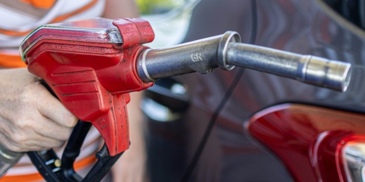 Person holding petrol pump nozzle