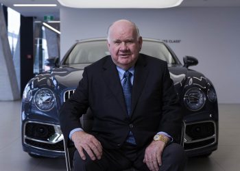 Sir Colin Giltrap sitting in front of Bentley Flying Spur