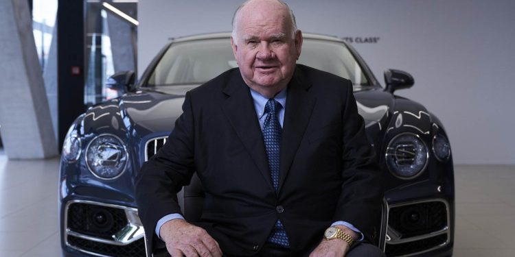 Sir Colin Giltrap sitting in front of Bentley Flying Spur