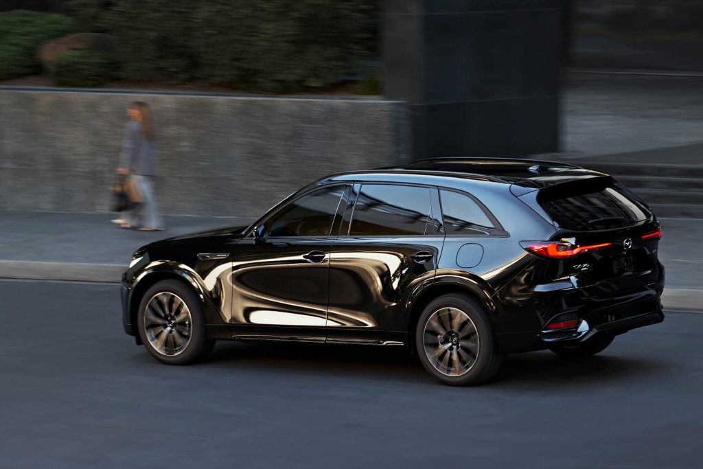 2025 Mazda CX-70 driving on road past person